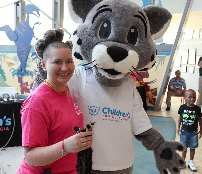 Mascot with participant at Brave the Shave event
